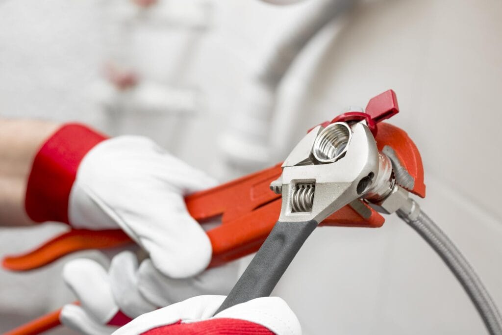 Plumber holding pipe wrenches for an emergency repair in Coachella