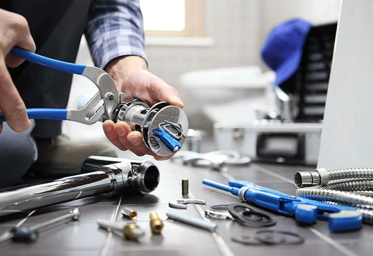 Technician repairing a plumbing fixture with professional tools in Coachella