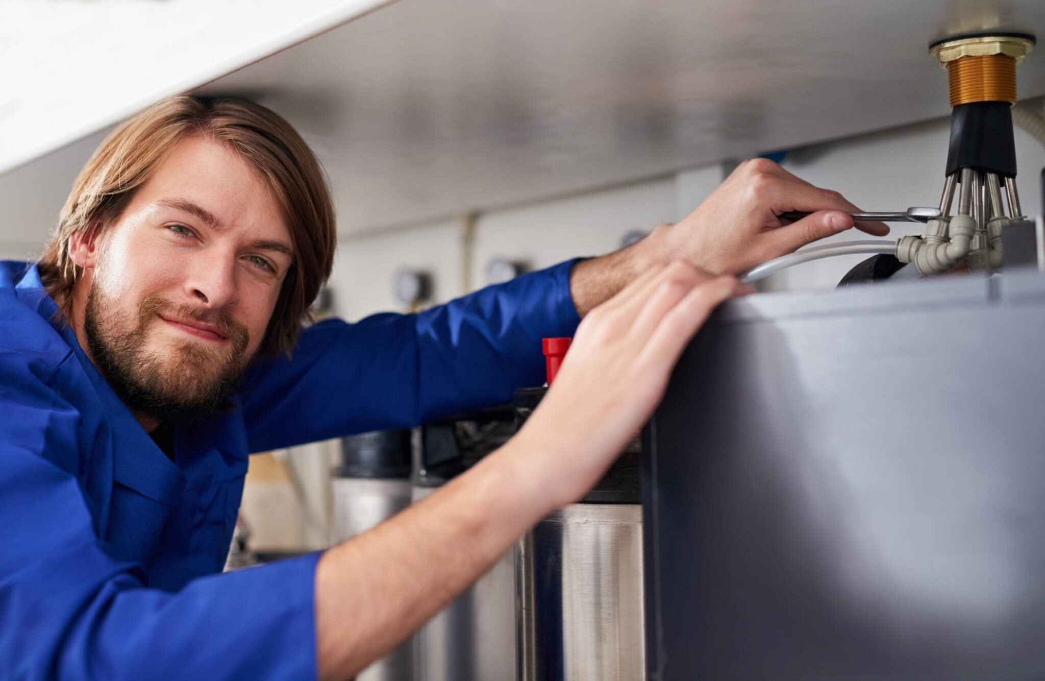 Technician servicing a residential water heater tank in Coachella